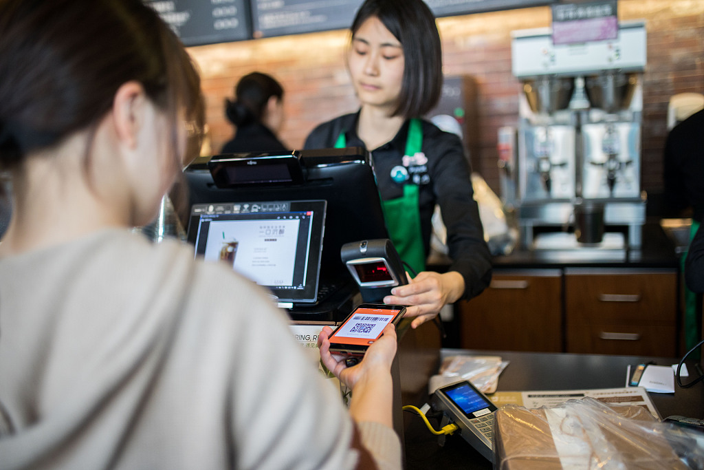 A customer pays with her phone in Hangzhou, Zhejiang Province. [File Photo: VCG]