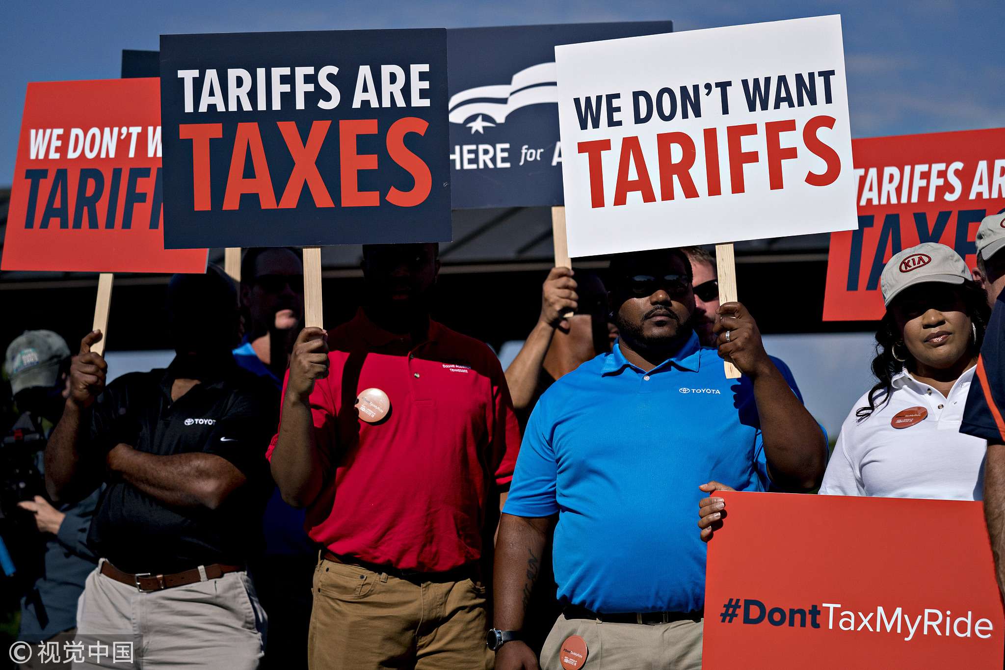 Autoworkers hold signs opposed to auto tariffs during a news conference on Capitol Hill in Washington on Thursday, July 19, 2018. [Photo: VCG]