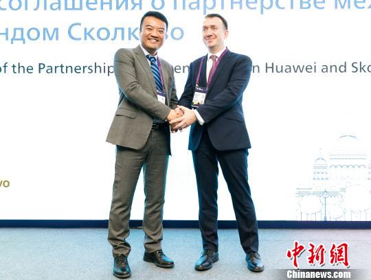 Lu Rui, the director of Huawei's Russian research center, shakes hands with Konstantin Parshin, the vice-president of the SKOLKOVO Foundation, in Moscow on Tuesday, October 16, 2018. [Photo: Chinanews.com]
