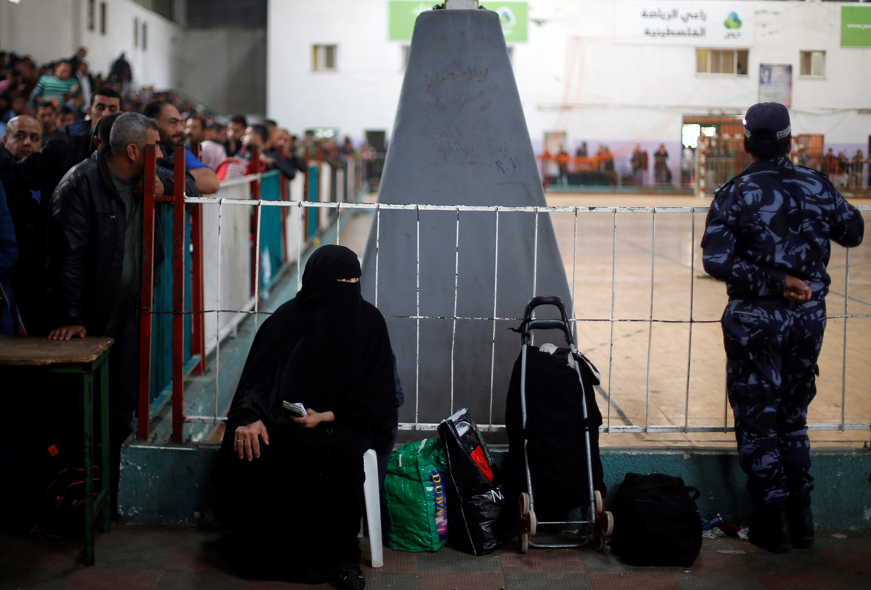 Palestinians wait for travel permits to cross the Rafah border into Egypt